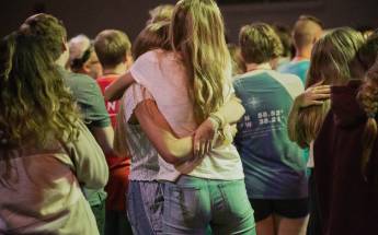 Zwei junge Mädchen umarmen sich in einer Menschenmenge